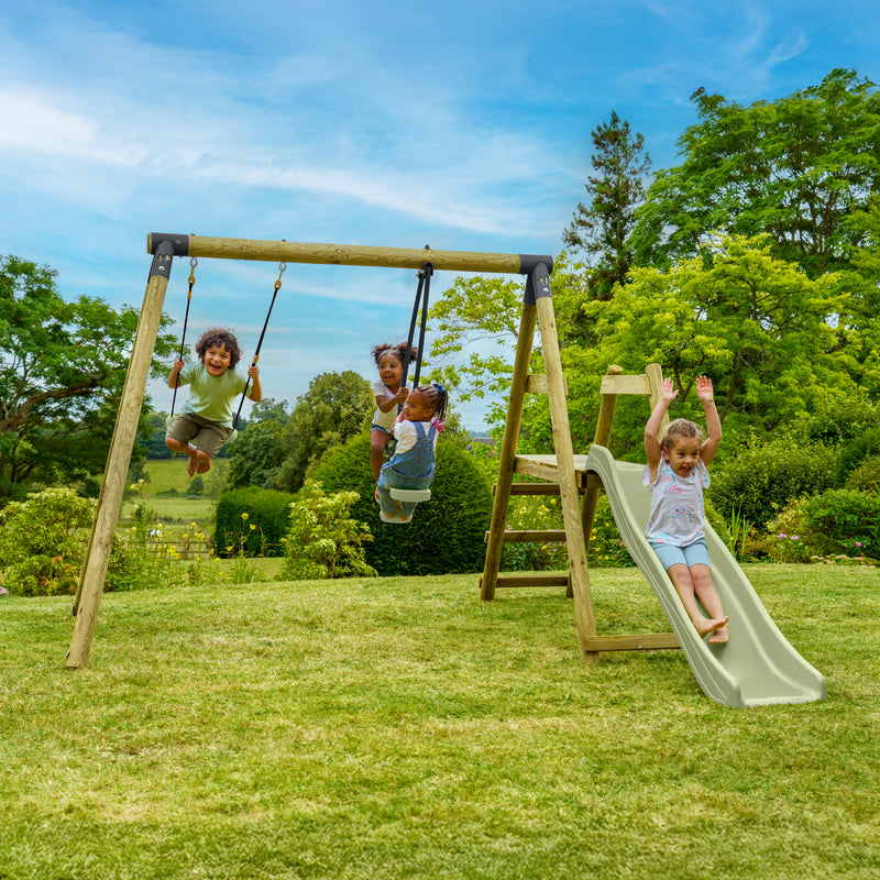 Quatre enfants jouent sur un portique de jeux en bois dans un jardin. Trois enfants se balancent sur des balançoires, tandis qu'un autre utilise la structure avec échelle et toboggan. La scène se déroule sur une pelouse entourée d’arbres, sous un ciel bleu.