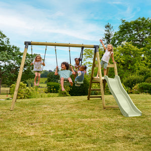 Cinq enfants jouent sur un portique de jeux en bois dans un jardin. Quatre enfants se balancent sur des balançoires, tandis qu'un autre utilise la structure avec échelle et toboggan. La scène se déroule sur une pelouse entourée d’arbres, sous un ciel bleu.