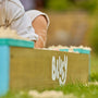 Bac à sable Bluey en bois avec le logo Bluey visible sur le côté.