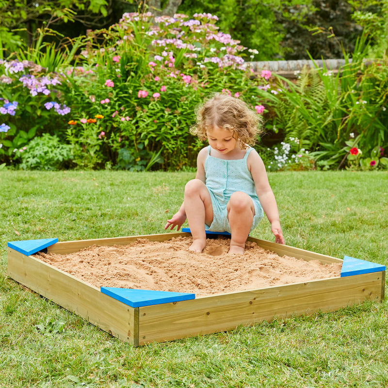 Une enfant joue dans le bac à sable.