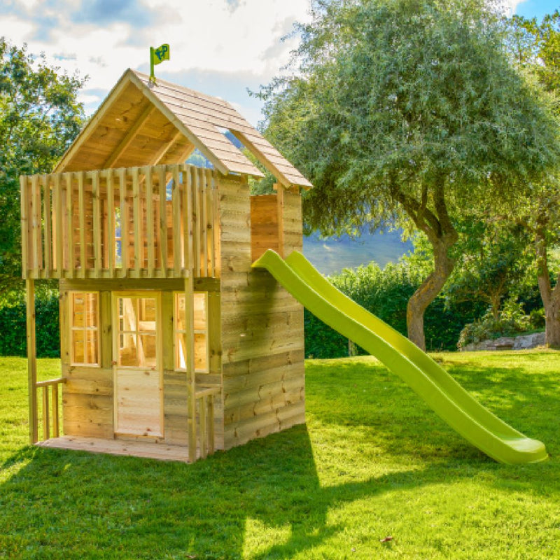 Maisonnette enfant en bois surélevée avec balcon et toboggan vert dans un jardin.