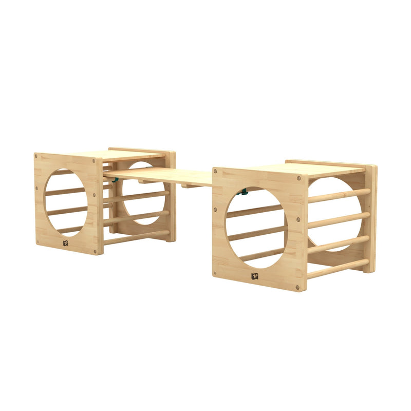 Deux cubes d’escalade pour enfants reliés par un pont toboggan.