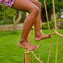 Jambes d’une enfant grimpant sur le filet d’escalade Skywood.