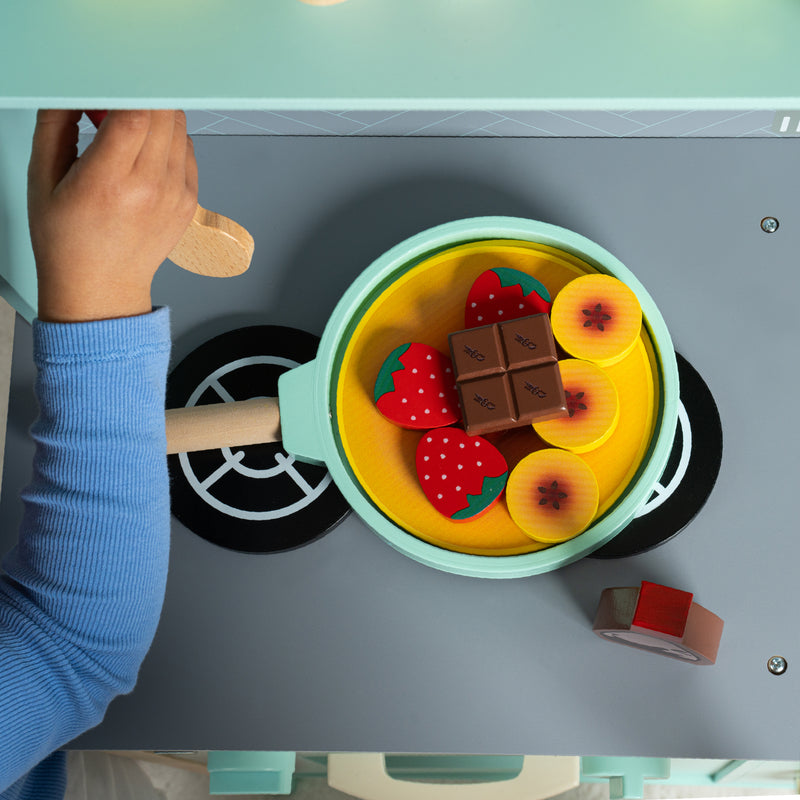 Vue du dessus de la poêle du set de crêpes qui contient une crêpe avec de la garniture prête à être manipulée par l’enfant.