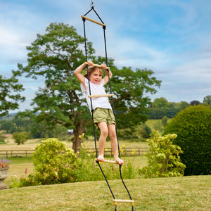 Une enfant grimpe sur l’échelle en bois TP Toys avec cinq barreaux.