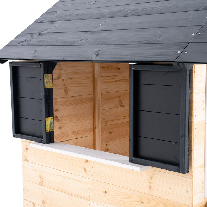 Détail de la fenêtre latérale d’une maisonnette en bois avec comptoir extérieur et volets.