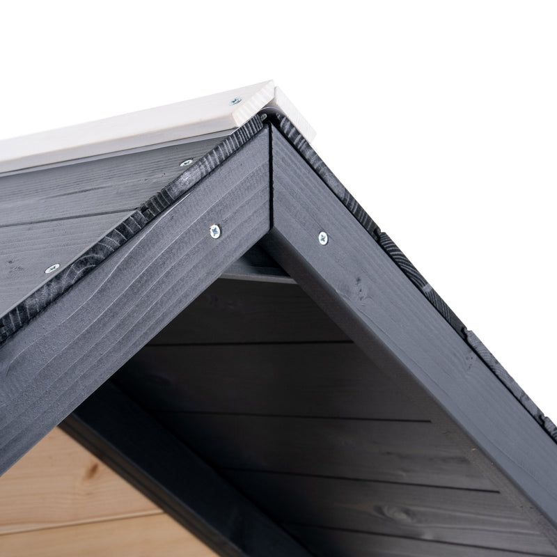 Gros plan sur le toit d’une maisonnette en bois blanche et grise.