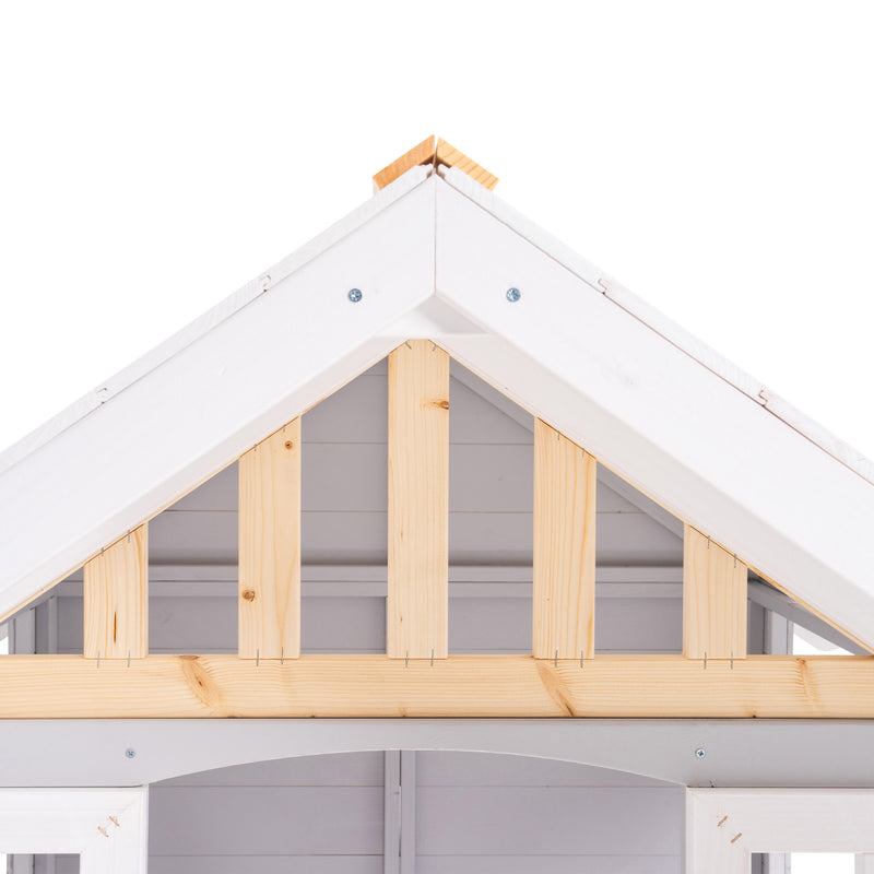 Gros plan sur le toit d’une maisonnette en bois blanche et grise.