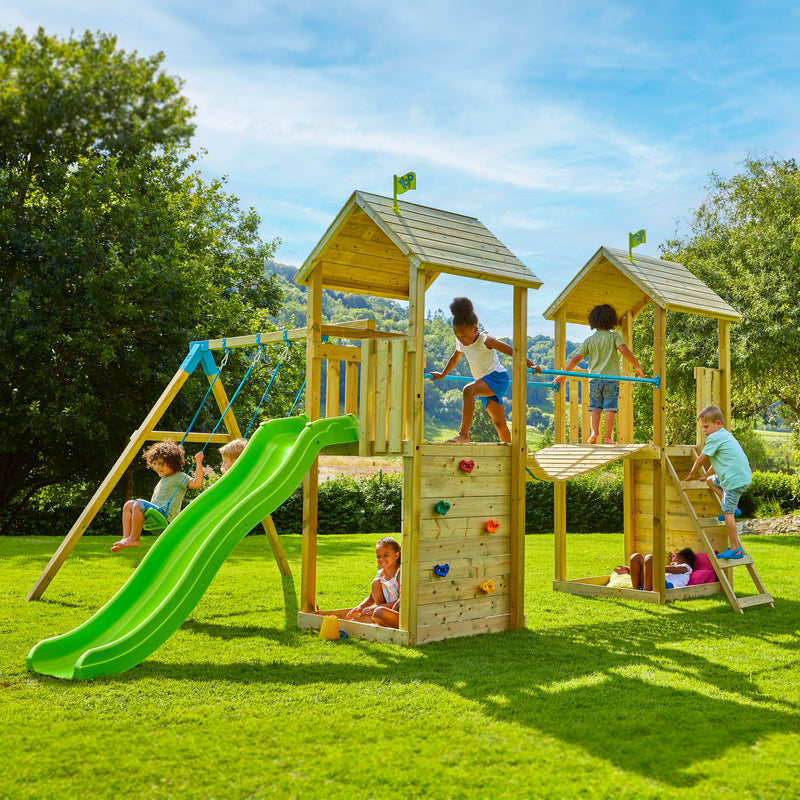 Aire de jeux complète où sept enfants s’amusent.