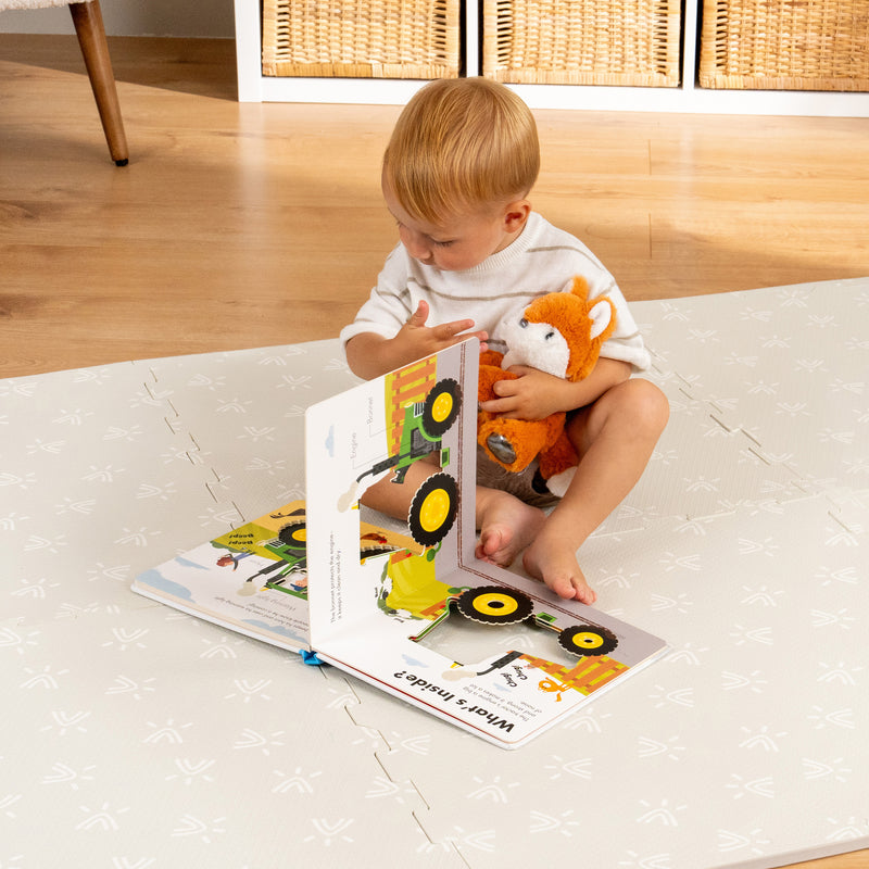 Enfant lisant un livre sur le tapis en mousse