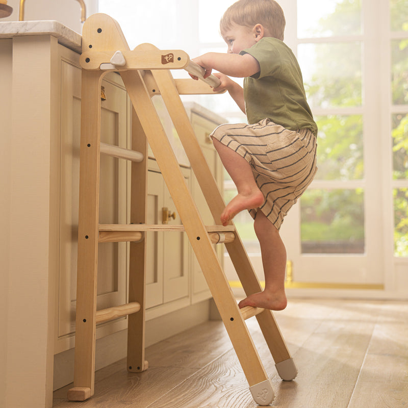 Enfant en train de monter sur la tour d’apprentissage pour jouer et apprendre.