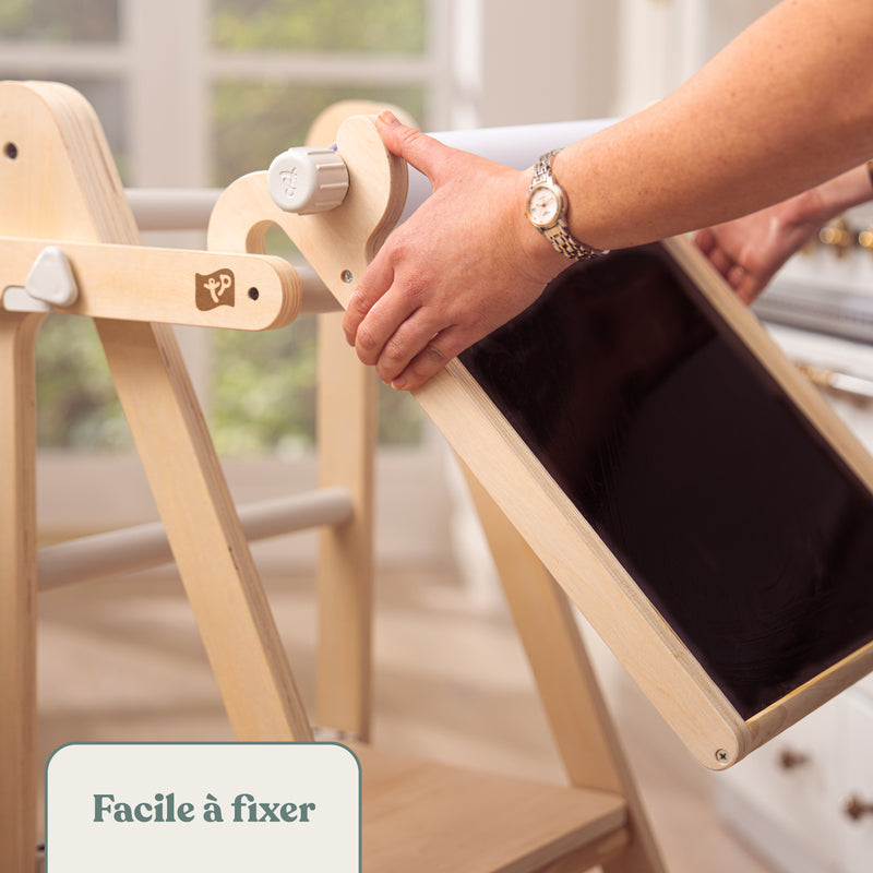 Image montrant que le tableau créatif se fixe facilement sur la tour d’apprentissage pour enfants.