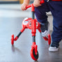 Un enfant s’apprête à monter sur le tricycle pliable SCUTTLEBUG BEETLE rouge et noir.