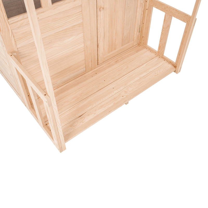 Bas de la véranda en bois raccordée à la maisonnette, montrant la structure et l’accès pour les enfants.